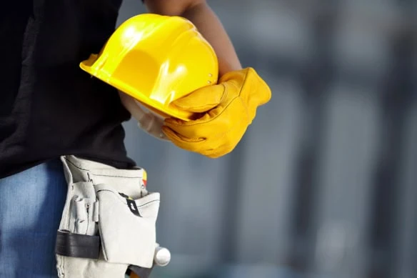 a construction worker holds a hard hat.
