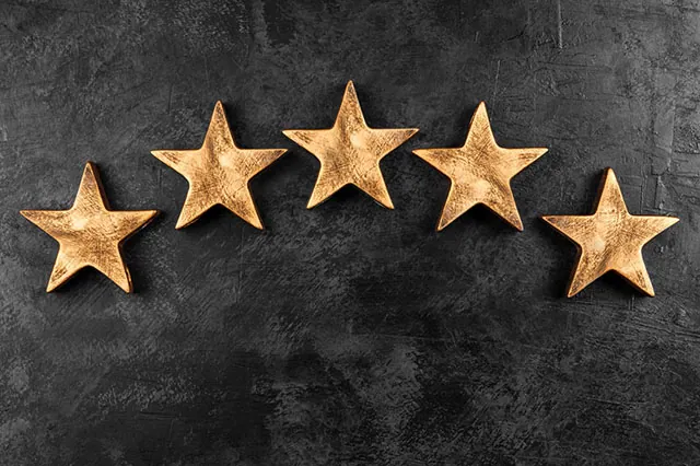 The 10 Best-Rated Dividend Aristocrats Right Now 5 five wooden stars against a black background.
