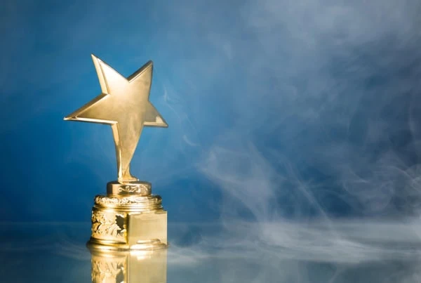 a gold trophy with a star against a blue background.
