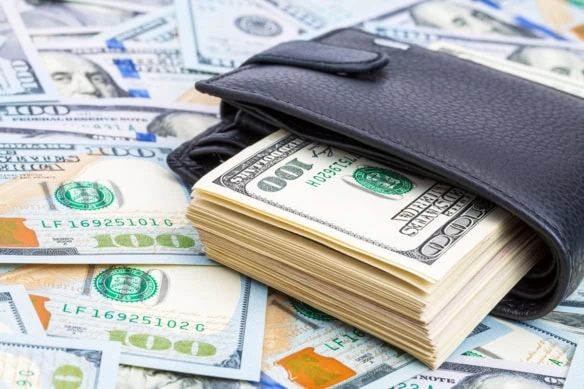 a wallet overflowing with hundred dollar bills.