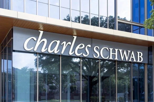 a charles schwab sign hanging in front of offices.