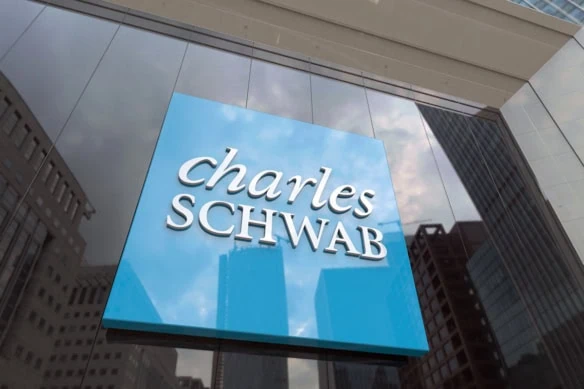 a charles schwab sign against a glass building.