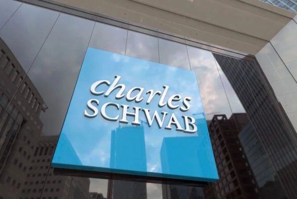 a charles schwab sign against a glass building.