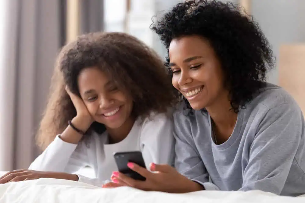 current bank account review mother and daughter smiling smartphone
