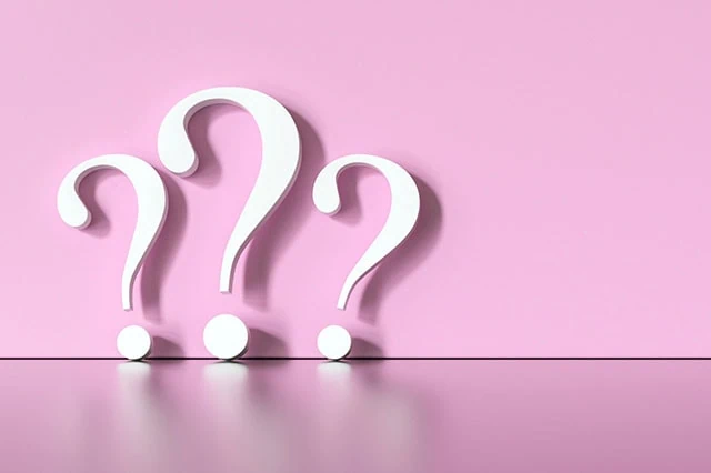 The Best REITs You Can Buy in 2025 9 white question marks against a pink background.