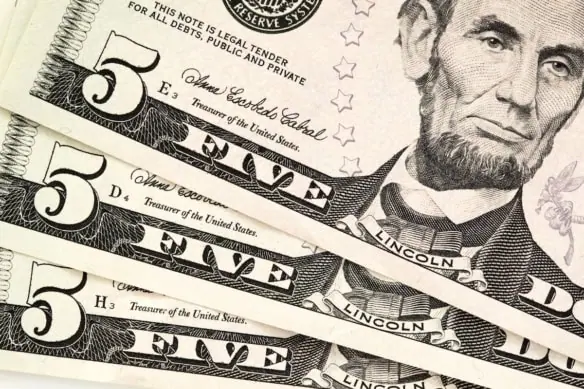 three five-dollar bills fanned out.