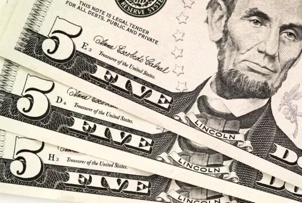 three five-dollar bills fanned out.