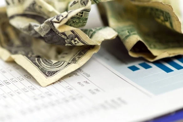 a crumpled dollar bill on top of data.