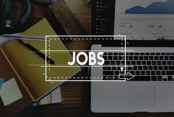 the word jobs is superimposed over a laptop and desk.