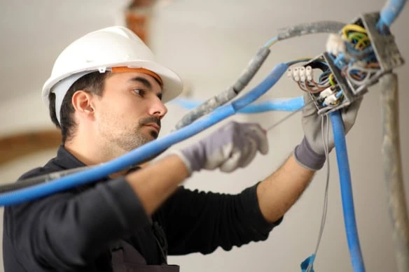 an electrician works on the electrical system in a house under construction.