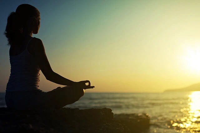 10 Best ETFs to Beat Back a Bear Market 8 a woman performing yoga at sunrise.