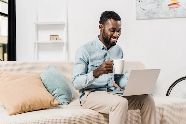 man sitting with coffee and laptop