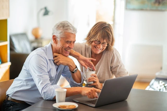 Are Financial Advisors Only for Inexperienced Investors? 6 smiling older couple sitting at table looking at laptop