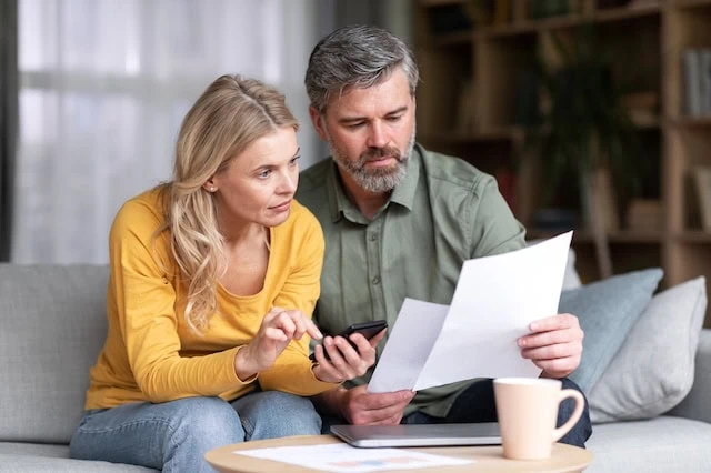 What Should I Do After a Layoff? 9 middle aged couple reviewing financial statements 640