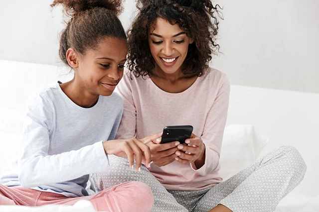 How to Teach Your Kids About Investing: 8 Savvy Parenting Tips 4 mother daughter teen smartphone app online 2
