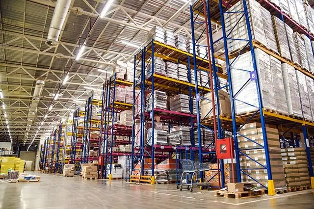 the inside of a large warehouse with stocked shelves.