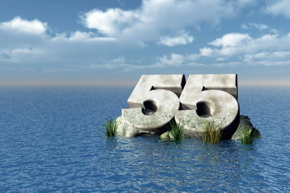 the number 55 carved out of rock floating in the ocean.