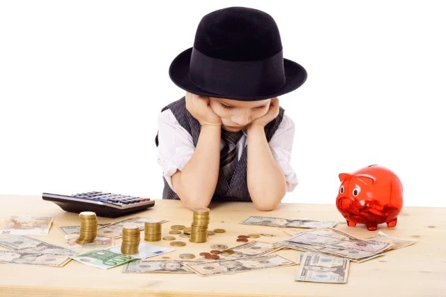 Kiddie Tax: What Is It, Who Must Pay, How Much + More 2 sad child at table with money