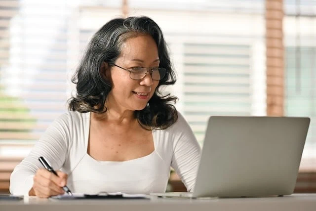 Should You Use a Financial Robo-Advisor? 6 Considerations 6 smiling senior woman looking at laptop 640