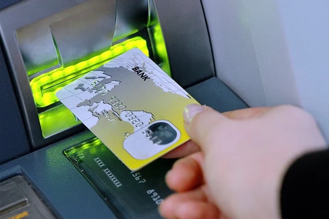 7 Best T. Rowe Price Funds to Buy and Hold 6 a person puts a debit card into an ATM.