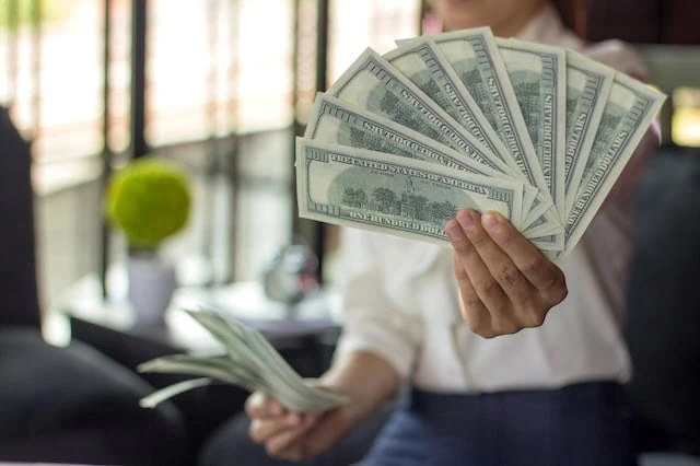 10 High-Paying Jobs You Can Get With 'Vanity Degrees' 2 well paid job holding money salary
