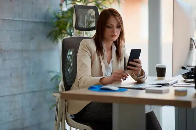 Can Bad Credit Impact Your Job Search? What to Know 9 woman looking at her smartphone intently