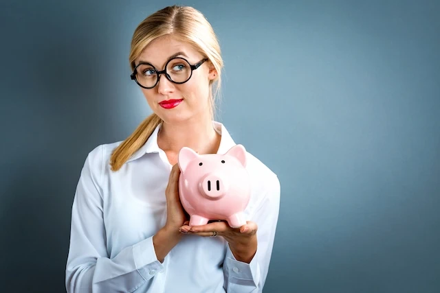 60 Personal Finance Statistics You Might Not Know (But Should!) 7 woman with glasses holding piggy bank