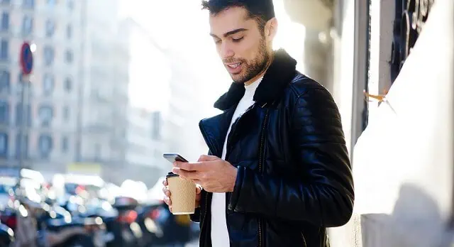 Can Bad Credit Impact Your Job Search? What to Know 12 young man with coffee looking at phone