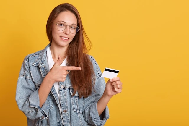 How to Get a Credit Card for the First Time: Starter Credit Cards 7 young teen with debit credit card yellow background